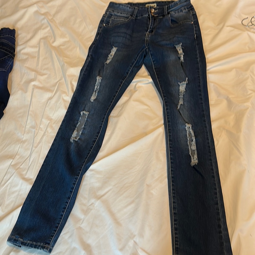 Medium denim blue jeans with cuts in the thigh area